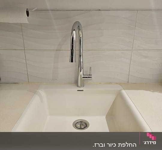 כיור עם ברז על משטח שיש במטבח